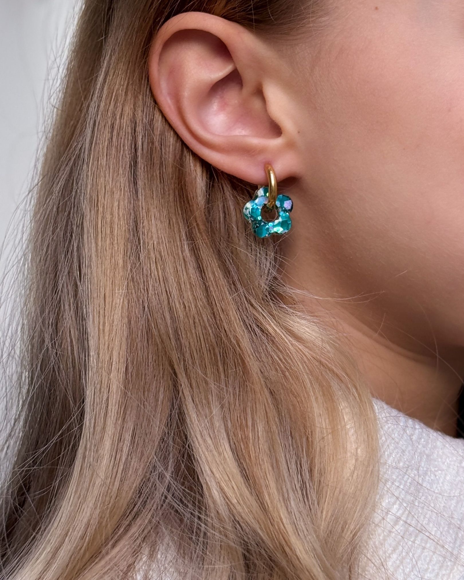 Boucle d’oreille créole fleur en résine turquoise pailletée sur anneau doré