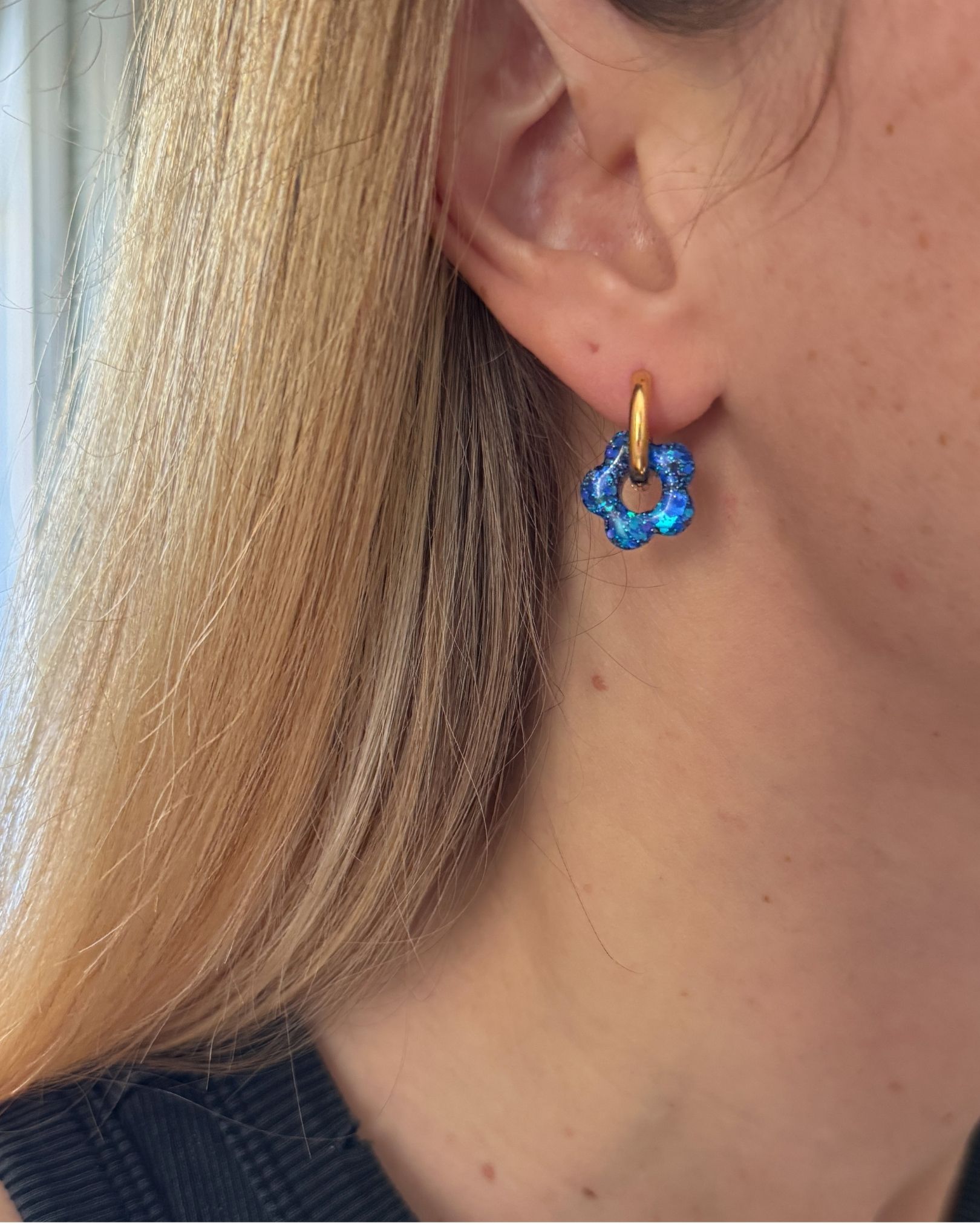 Boucle d’oreille créole fleur en résine bleue pailletée sur anneau doré