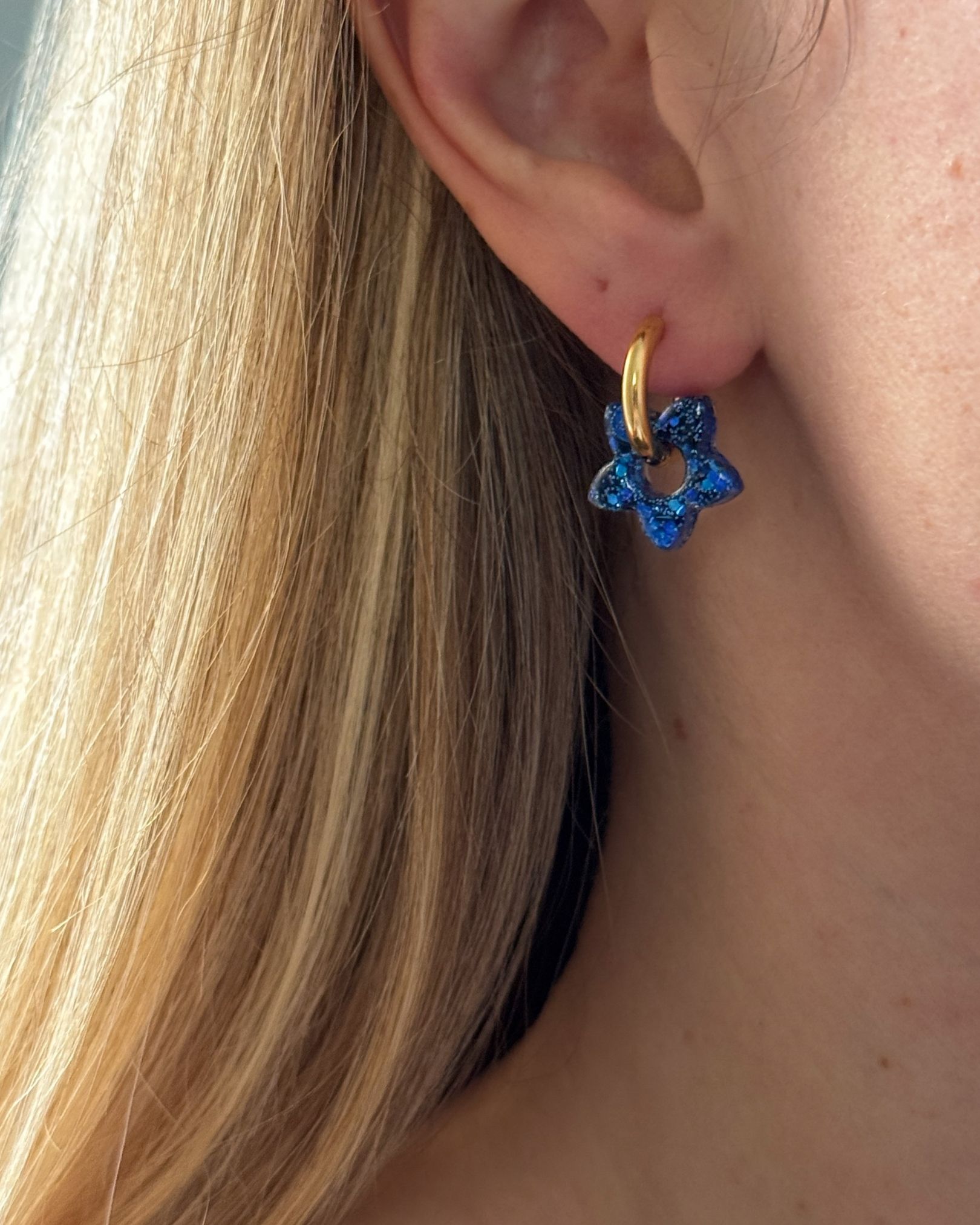 Boucle d’oreille créole fleur en résine bleue et paillettes sur anneau doré